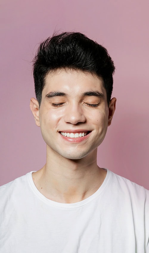 Smiling young man with healthy teeth and confident smile after dental implant treatment in Beverly Hills